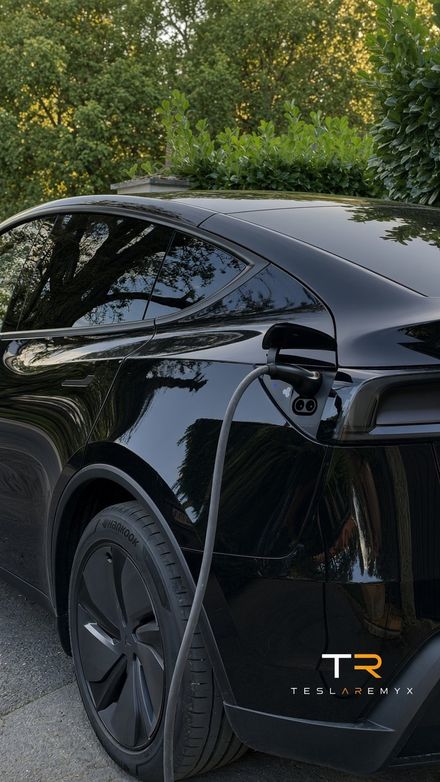 Ma Tesla Model Y noire branchée en recharge à domicile, câble sur la trappe arrière gauche