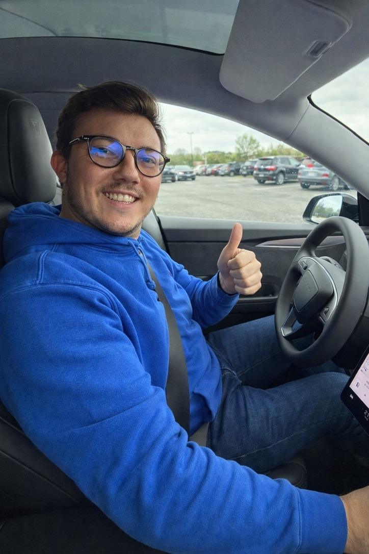 Rémy, pouce levé, au volant d’une Tesla Model Y